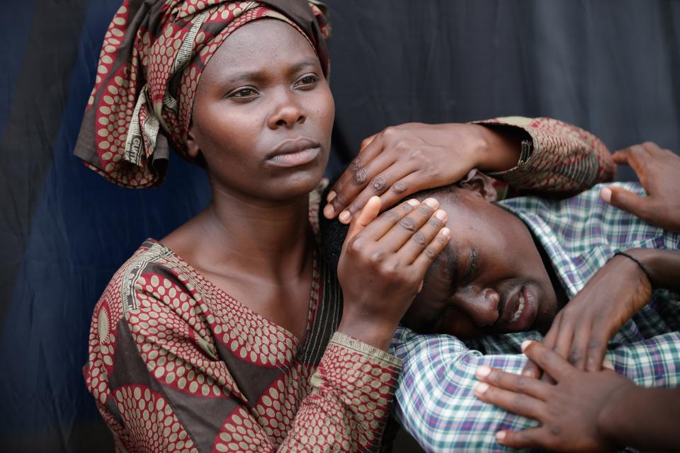 Una mujer consuela a Bizimana Emmanuel en el aniversario del genocidio. (Chip Somodevilla/Getty Images)