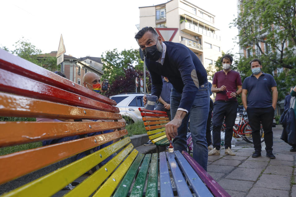 FILE - In this Friday, May 7, 2021 filer, Italian lawmaker Alessandro Zan paints a bench in the colors of the rainbow, in Milan, Italy. The Vatican has formally opposed proposed Italian legislation that seeks expand anti-discrimination protections to people who are gay and transgender, along with women and people with disabilities, the leading Italian daily Corriere della Sera reported on Tuesday. Activists immediately denounced Vatican meddling in the Italian legislative process as “unprecedented. Italian politicians and activist groups reacted strongly to what they see as an attempt to derail the so-called Zan Law, named for a Democratic Party lawmaker and gay rights activist Alessandro Zan. (AP Photo/Luca Bruno, File)