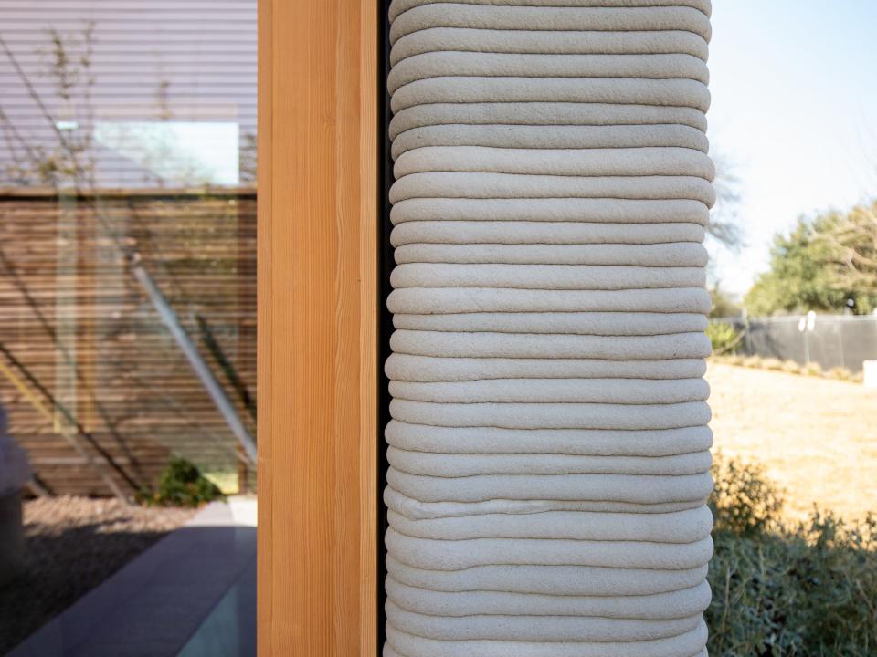 A 3D printed wall next to a wooden and glass panel.