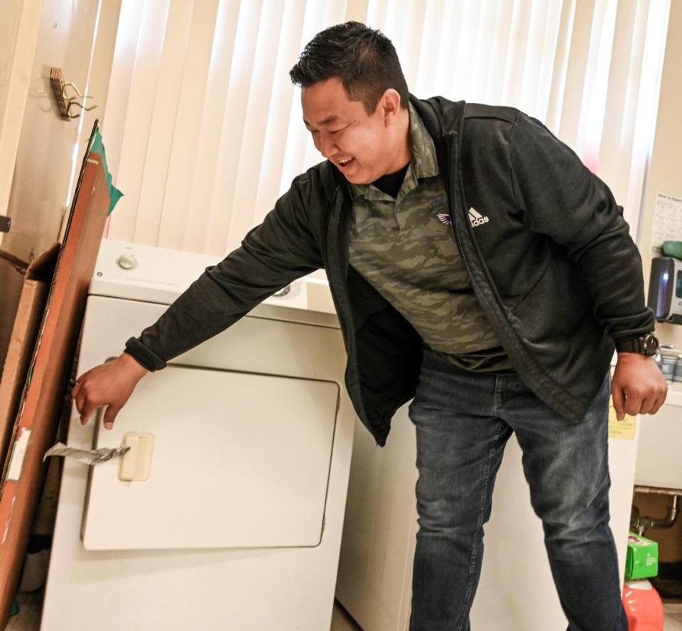 Fort Miller Middle School teacher Eric Calderon shows how the school’s current dryer door is held shut by a piece of duct tape on Monday, March 27, 2023. Calderon, with help from trustee Andy Levine, was able to secure funding for a new washer and dryer for not only Fort Miller, but all middle schools throughout the district to give low-income students access to laundry equipment to keep their clothes clean.