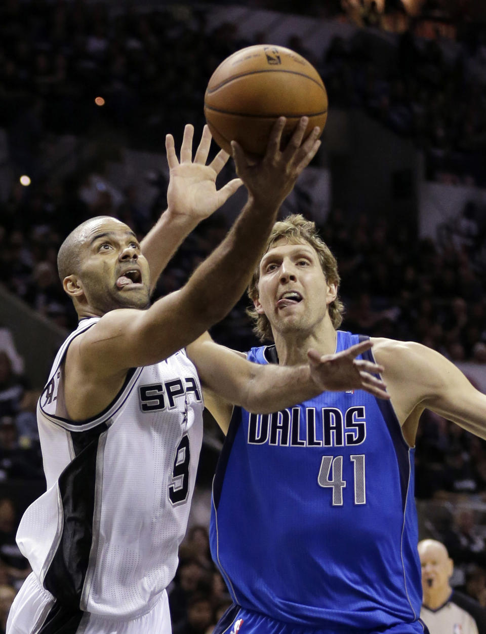 San Antonio Spurs' Tony Parker (9), of France, shoots around Dallas Mavericks' Dirk Nowitzki (41), of Germany, during the first quarter of Game 1 of the opening-round NBA basketball playoff series on Sunday, April 20, 2014, in San Antonio. (AP Photo/Eric Gay)