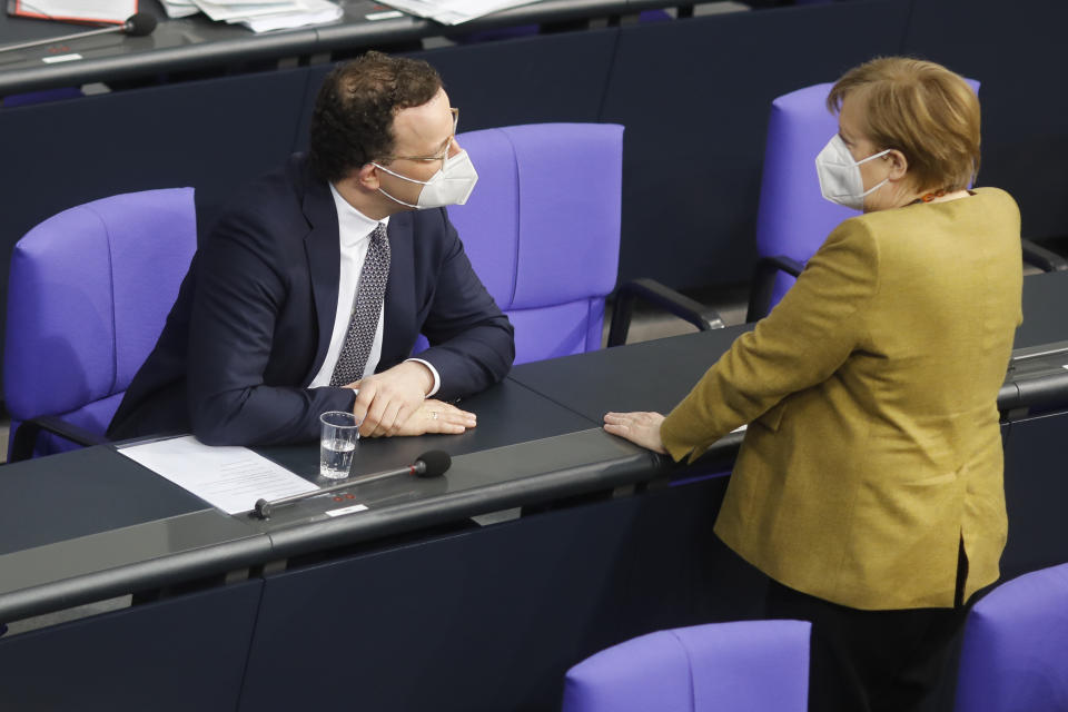 German Chancellor Angela Merkel, right, speaks with German Health Minister Jens Spahn during a debate of the German Parliament Bundestag about the coronavirus outbreak situation in Berlin, Germany, Thursday, March 4, 2021. (AP Photo/Markus Schreiber)