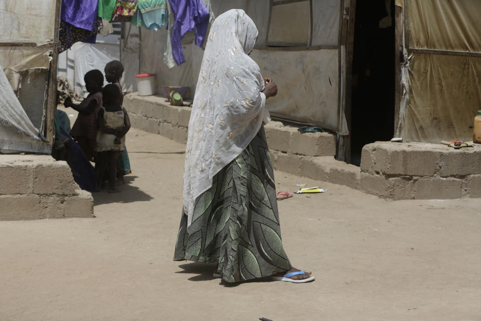 In this photo taken on Tuesday, Feb. 19, 2019, Maria Saleh a woman who says she was assaulted and displaced by Islamist extremist is photographed at Malkohi camp in Yola, Nigeria. Maria is from the town of Madagali in Adamawa, has a child by a Boko Haram fighter who assaulted and then enslaved her for months following a 2014 attack that killed her husband. Two of her children were taken by militants. (AP Photo/ Sunday Alamba)