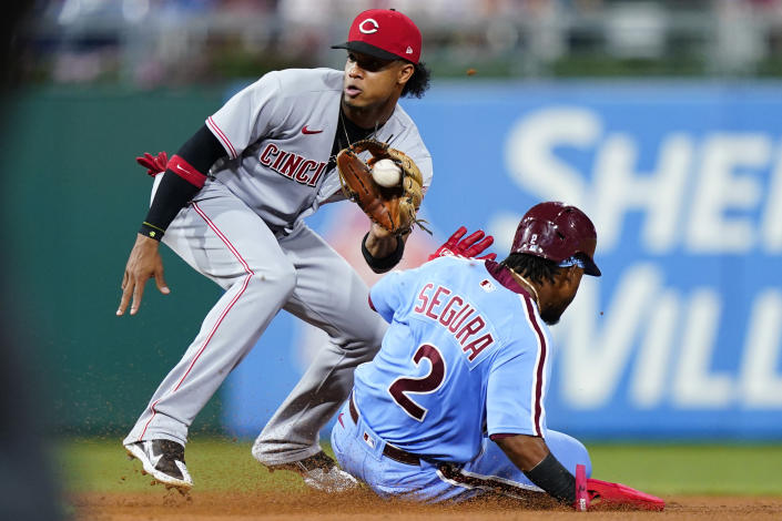 Philadelphia Phillies' Jean Segura, right, tries to steal second base past Cincinnati Reds shortstop Jose Barrero during the fourth inning of a baseball game, Thursday, Aug. 25, 2022, in Philadelphia. Segura was tagged out on the attempt. (AP Photo/Matt Slocum)