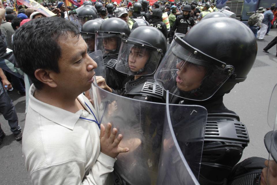 A protester confronts police during a march against President Rafael Correa's policies on mining in Quito, Ecuador, Thursday March 22, 2012.  Protesters reached Ecuador's capital on Thursday after a two-week march from the Amazon to oppose plans for large-scaling mining projects on their lands. (AP Photo/Dolores Ochoa)