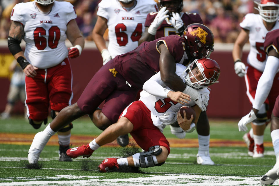 Miami-Ohio quarterback Brett Gabbert (5) is tackled by Minnesota defensive lineman Thomas Rush on a short run during the first half of an NCAA college football game on Saturday, Sept. 11, 2021, in Minneapolis. (AP Photo/Craig Lassig)