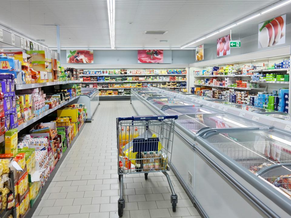 An Aldi shopping cart sits idly in the store.