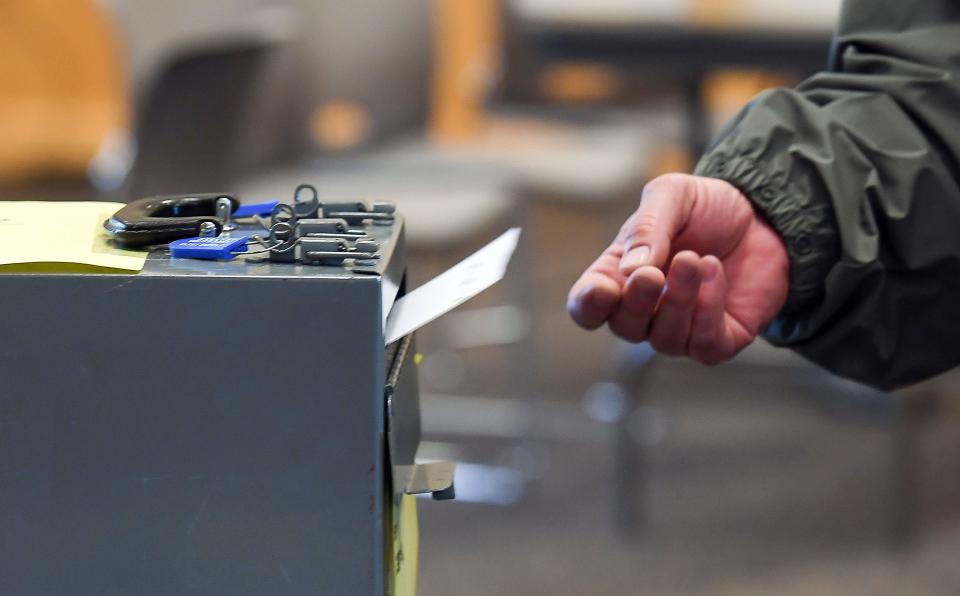 A voter submits his ballot for the school board election in 2019 in Sioux Falls.