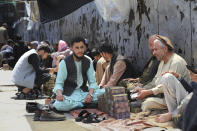 Afghan money changers wait for customers at a currency exchange market in Kabul, Afghanistan, Tuesday, April 23, 2024. (AP Photo/Siddiqullah Alizai)