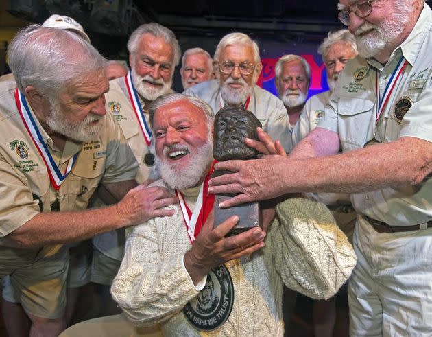 Jon Auvil, center, receives an Ernest Hemingway bust and congratulations after he won the 2022 Hemingway Look-Alike Contest at Sloppy Joe's Bar in Key West, Fla. (Photo: Andy Newman/Florida Keys News Bureau via AP)
