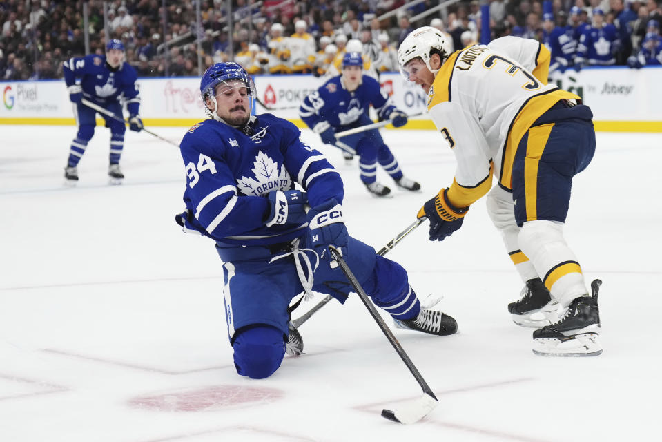 Toronto Maple Leafs forward Auston Matthews (34) stumbles as Nashville Predators defenseman Jeremy Lauzon (3) defends during the second period of an NHL hockey match in Toronto on Saturday, Dec. 9, 2023. (Nathan Denette/The Canadian Press via AP)