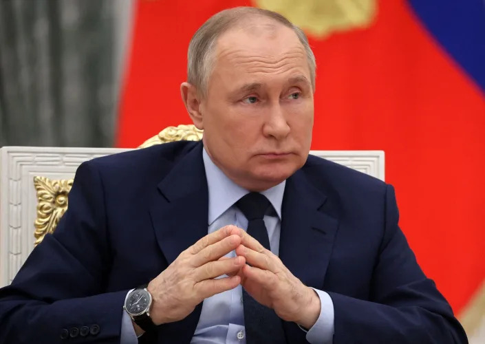 putin puts the tips of his fingers together and looks unamused
