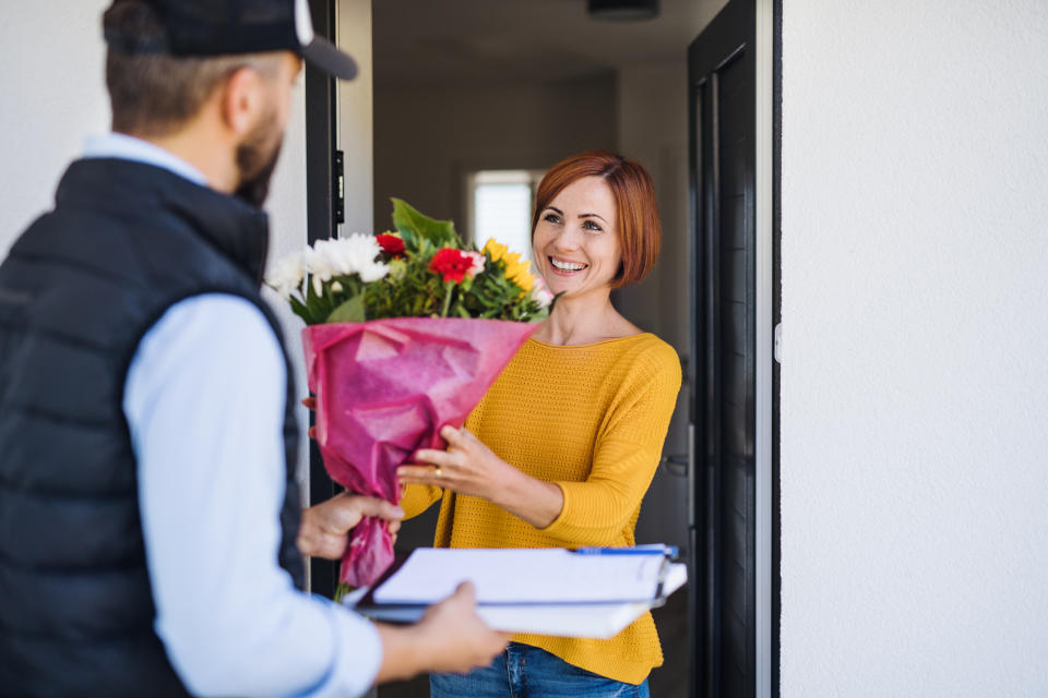 Delivery man and young woman standing in the doorway.