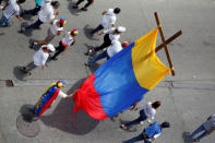 Demonstrators hold a cross as they take part in a rally to honour victims of violence during a protest against Venezuela's President Nicolas Maduro's government in Caracas. REUTERS/Christian Veron