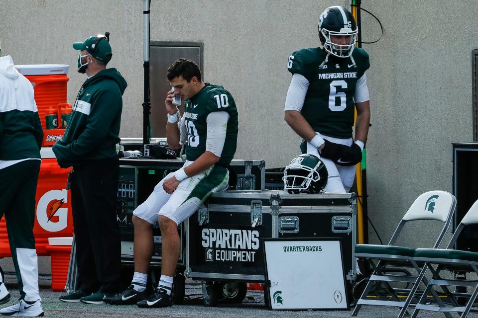Payton Thorne speaks on the phone as Theo Day (6) walks by during the second half of MSU's 24-0 loss to Indiana, Nov. 14, 2020.