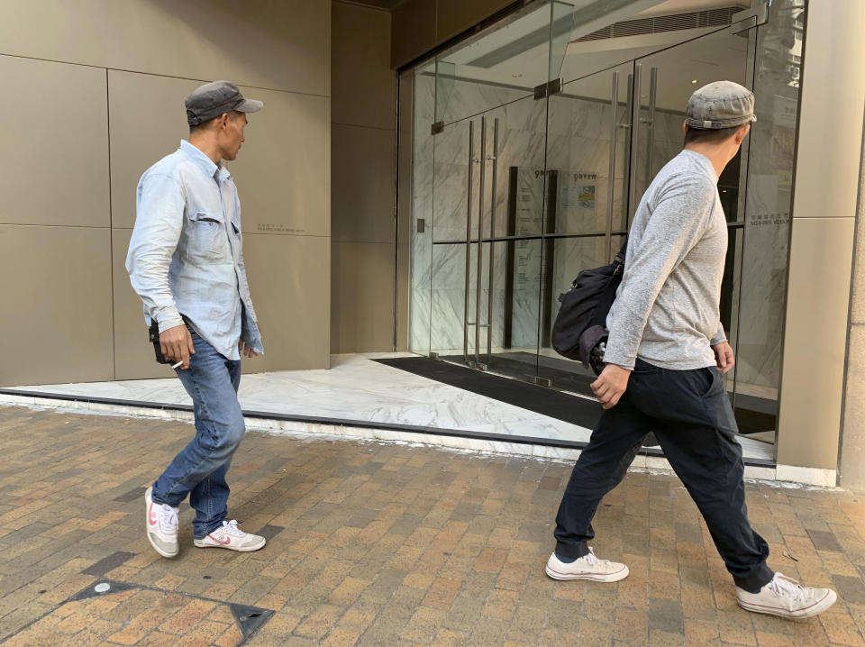 People walk past a building listed as the address of China Innovation Investment Limited in Hong Kong, Saturday, Nov. 23, 2019. Australia’s Treasurer on Saturday labeled detailed accusations of China infiltrating and disrupting democratic systems in Australia, Hong Kong and Taiwan as “very disturbing.” A Chinese defector revealed he was part of the Hong Kong-based investment firm, which was a front for the Chinese government to conduct political and economic espionage in Hong Kong, including infiltrating universities and directing bashings and cyber attacks against dissidents. (AP Photo/Ng Han Guan)