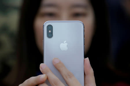 FILE PHOTO : An attendee uses a new iPhone X during a presentation for the media in Beijing, China October 31, 2017. REUTERS/Thomas Peter