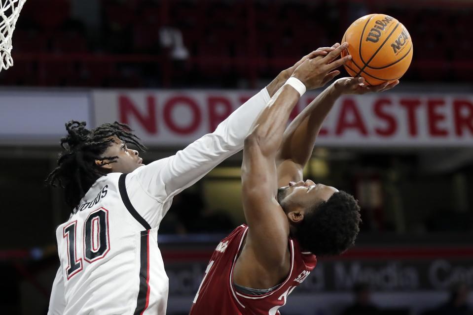 Northeastern's Harold Woods (10) blocks a shot by Charleston's Jaylon Scott during the first half of an NCAA college basketball game, Saturday, Jan. 21, 2023, in Boston. (AP Photo/Michael Dwyer)