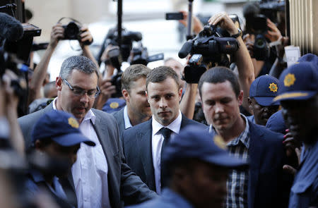 South African Olympic and Paralympic track star Oscar Pistorius (C) arrives for the verdict in his murder trial at the high court in Pretoria September 11, 2014. REUTERS/Siphiwe Sibeko