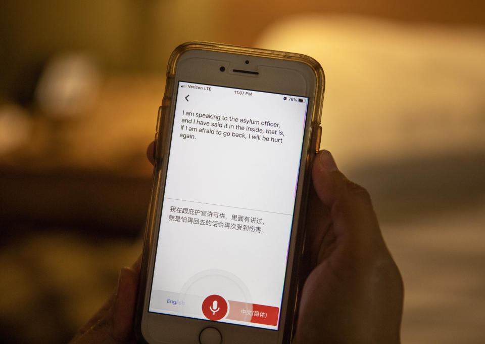 Volunteer Laura Kessling uses a translation app on her phone to communicate with Cai Han, an asylum seeker from China, that was recently released on bond from Stewart Detention Center, Thursday, Nov. 14, 2019, in Columbus, Ga. Kessling, a volunteer with Paz Amigos, finds accommodations in hotels or the homes of fellow volunteers for detainees who are released from the rural ICE facility at night at a bus station and have no local family or a place to stay. (AP Photo/David Goldman)