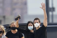 Michael Kovrig, center right, waves to media as his wife Vina Nadjibulla, centre left, and sister Ariana Botha, left, after his arrival at Pearson International Airport in Toronto, Saturday, Sept. 25, 2021. China, the U.S. and Canada completed a high-stakes prisoner swap Saturday with joyous homecomings for Kovrig and Michael Spavor, two Canadians held by China and for an executive of Chinese global communications giant Huawei Technologies charged with fraud. (Frank Gunn /The Canadian Press via AP)