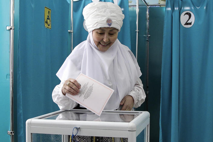 A woman wearing Kazakh National Costume casts her ballot at a polling station in Astana, Kazakhstan, Sunday, March 19, 2023. Voters in Kazakhstan cast ballots on Sunday after a short but active campaign for seats in the lower house of parliament that is being reconfigured in the wake of deadly unrest that gripped the resource-rich Central Asian nation a year ago. (AP Photo/Ilyas Omarov)