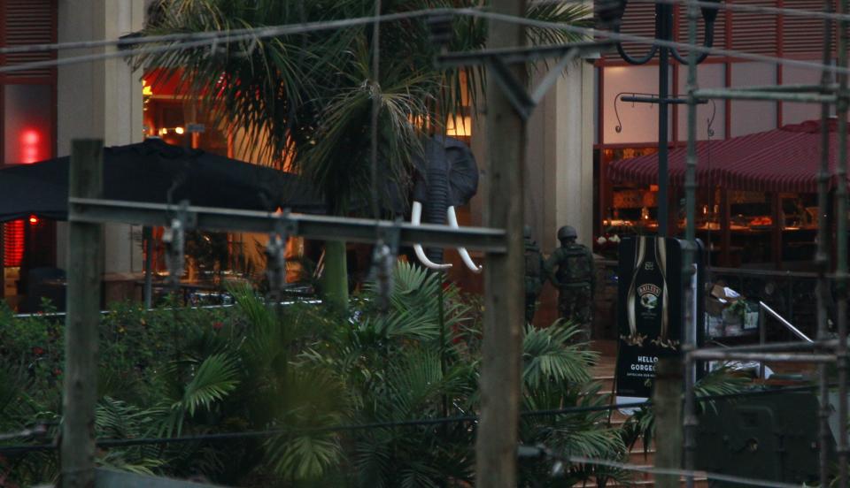 Soldiers from the Kenya Defence Forces (KDF) are seen entering the Westgate Shopping Centre in the capital Nairobi, September 23, 2013. Heavy and sustained gunfire was heard from the Kenyan shopping mall where at least 68 people were killed in an attack by the Somali al Shabaab group, suggesting a possible assault by Kenyan security forces, a Reuters witness at the scene said. REUTERS/Thomas Mukoya (KENYA - Tags: SOCIETY CIVIL UNREST CRIME LAW)