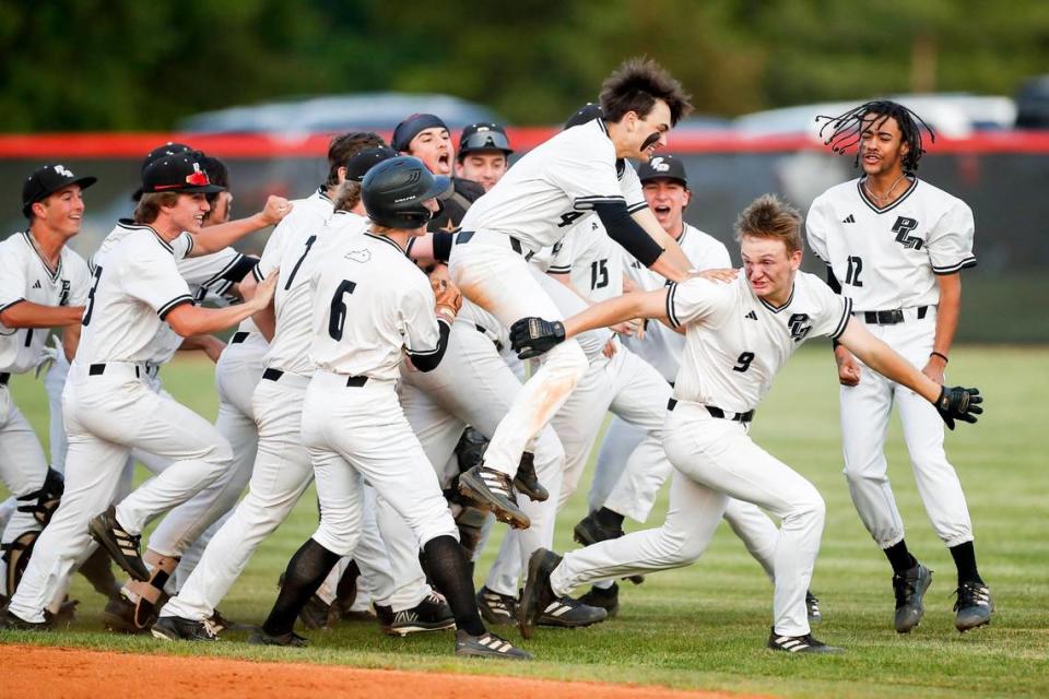Paul Laurence Dunbar’s Scott Kendrick (9) is swarmed by his teammates after hitting a game-winning RBI double against Tates Creek in the 43rd District semi-finals at Paul Laurence Dunbar High School on Wednesday.