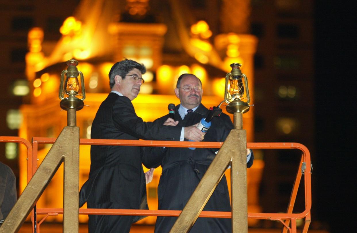 FILE - Ron Klein, CEO of Macy's New York (left) and Allen Weisselberg, CFO of the Trump Organization, light the Chanukah Menorah at 59th and 5th Ave on December 8, 2004. 