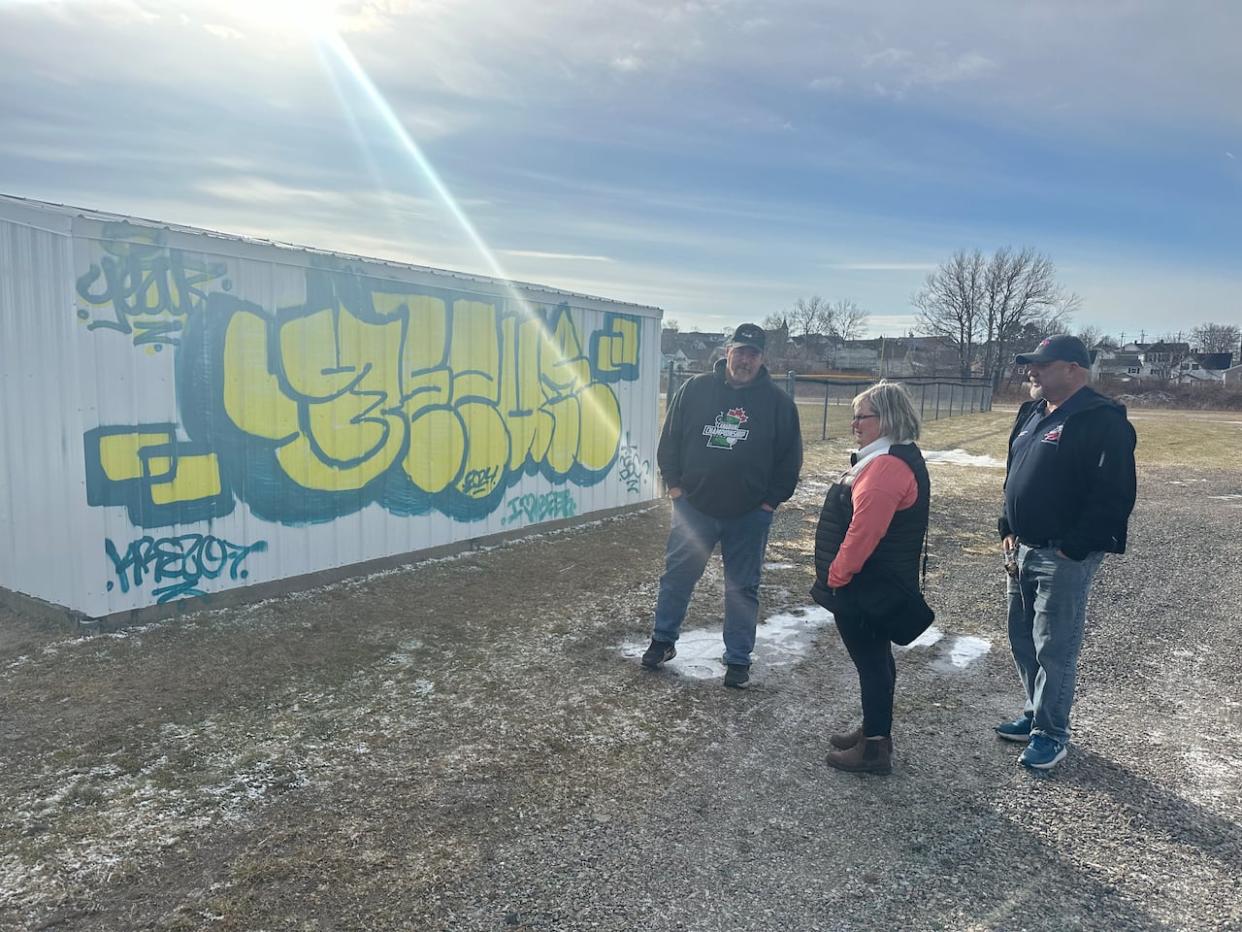 Officials with the local little league baseball organization survey recently painted graffiti at the Joe Scott Memorial Field in Sydney Mines, N.S. (Holly Conners/CBC - image credit)
