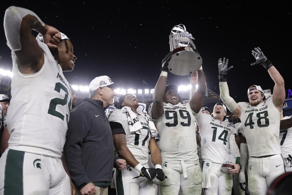Michigan State's Raequan Williams (99) holds up the trophy after the team's Pinstripe Bowl NCAA college football game against Wake Forest on Friday, Dec. 27, 2019, in New York. Michigan State won 27-21. (AP Photo/Frank Franklin II)