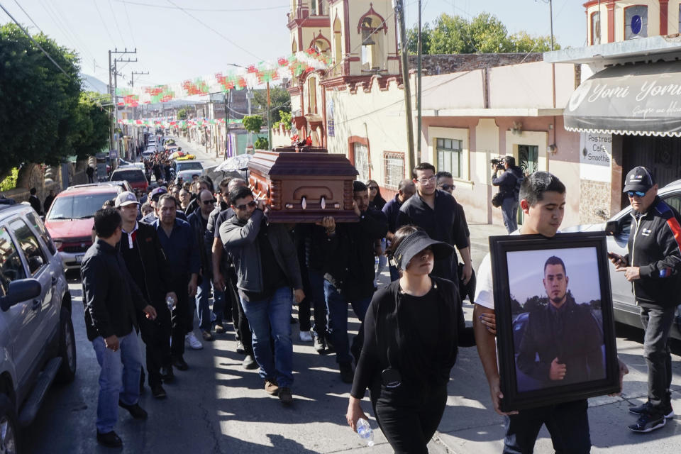 Friends and family of David Hernandez carry his coffin during a funeral procession, in Salvatierra, Guanajuato state, Mexico, Tuesday, Dec 19, 2023. Survivors of a massacre in central Mexico told investigators that a group of people turned away from a holiday party on Sunday, returned later with gunmen who killed several attendees including Hernandez, and wounded over a dozen. (AP Photo/Mario Armas)