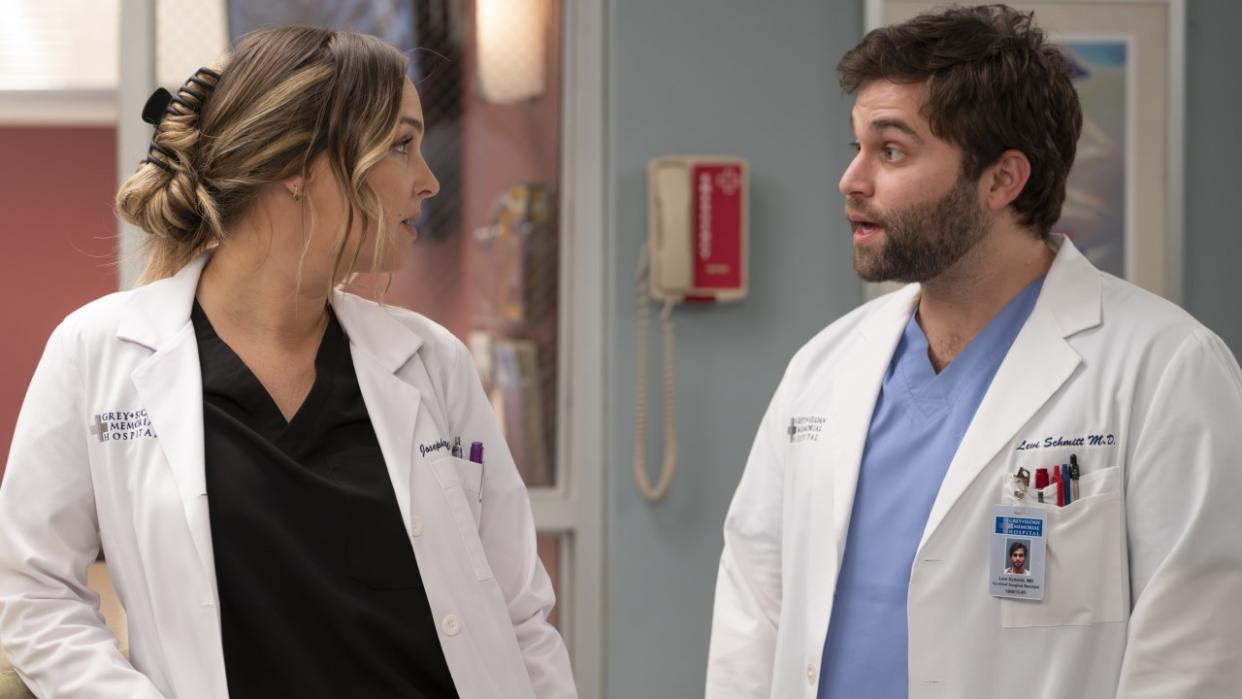  Jo Wilson (Camilla Luddington) talks to a shocked Levi Schmitt (Jake Borelli) in the hospital during an episode of Grey's Anatomy. 