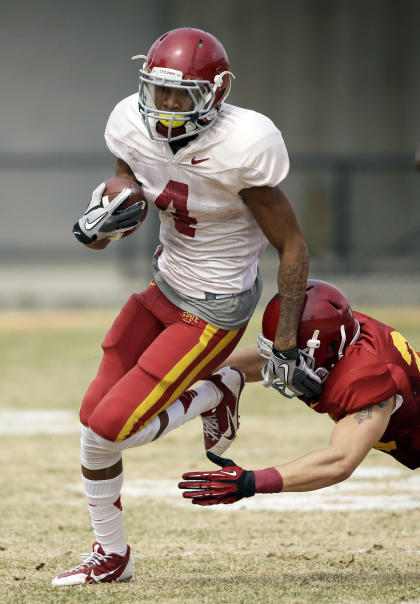 Iowa State wide receiver P.J. Harris runs from defensive back Darian Cotton, right, after making a reception during an annual NCAA college spring football game on Saturday, April 12, 2014, in Ames, Iowa. (AP Photo/Charlie Neibergall)