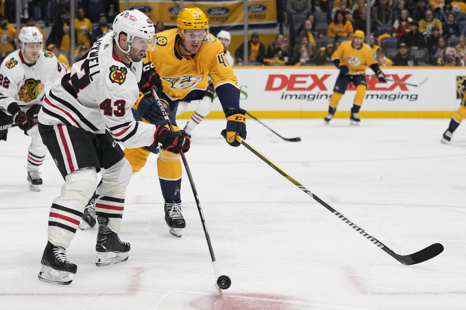 Chicago Blackhawks center Colin Blackwell (43) passes the puck past Nashville Predators right wing Michael McCarron (47) during the second period of an NHL hockey game Tuesday, Jan. 2, 2024, in Nashville, Tenn. (AP Photo/George Walker IV)