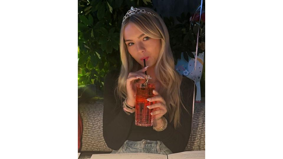 Jennie Garth's daughter Fiona poses with a straw in her mouth wearing a tiara