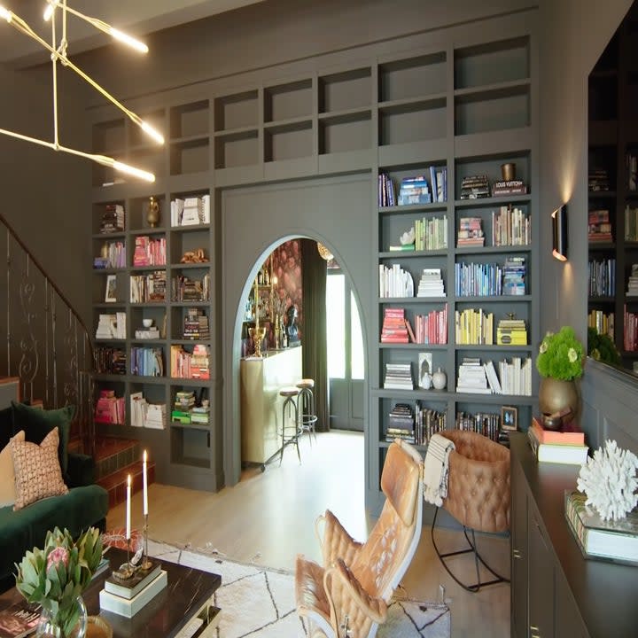 The entertainment room has a huge book shelf built into the wall