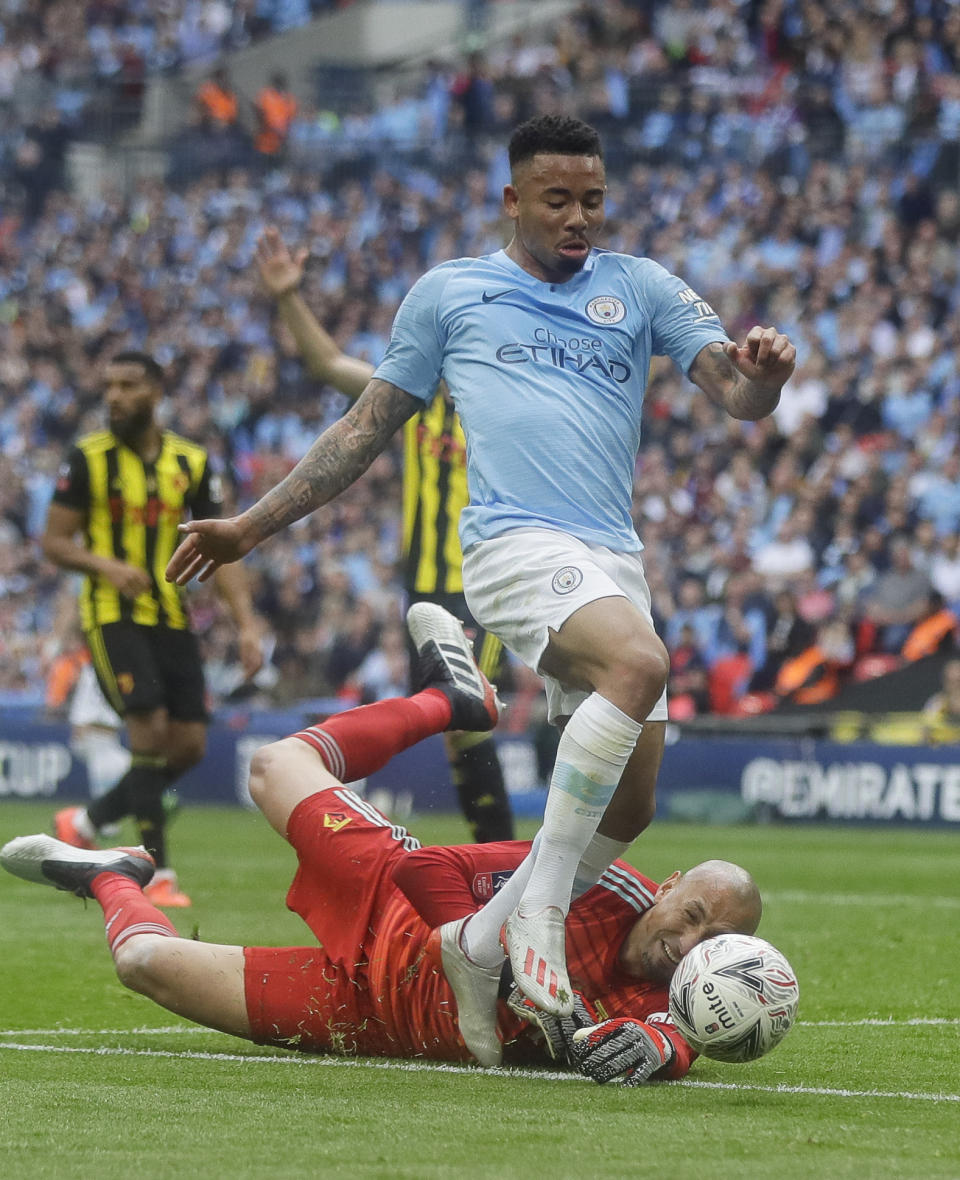 Watford's goalkeeper Heurelho Gomes tries to stop Manchester City's Gabriel Jesus during the English FA Cup Final soccer match between Manchester City and Watford at Wembley stadium in London, Saturday, May 18, 2019. (AP Photo/Kirsty Wigglesworth)
