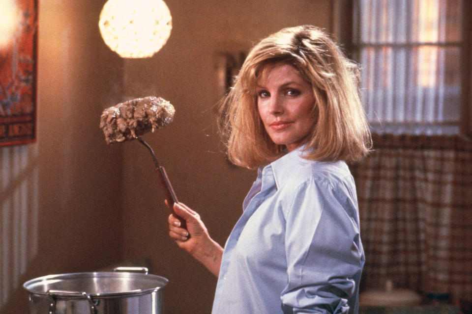 Priscilla Presley holds a roast with a fork in a still from The Naked Gun.