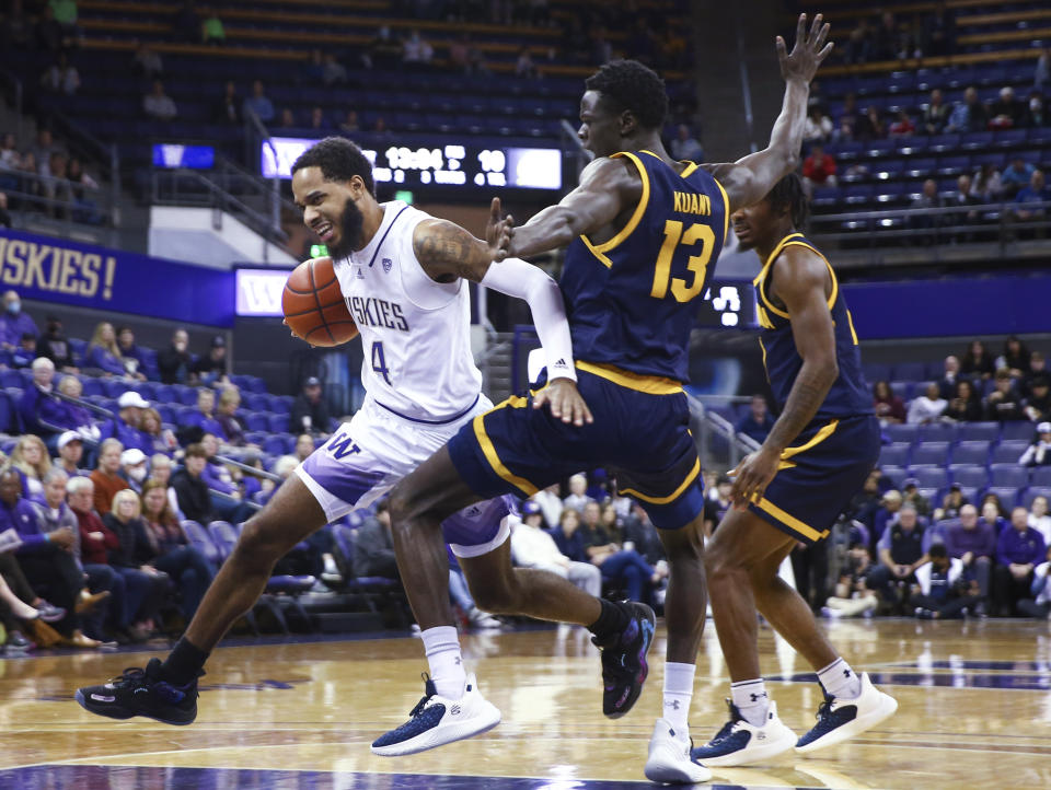 Washington guard PJ Fuller II (4) drives around California forward Kuany Kuany (13) during the first half of an NCAA college basketball game Saturday, Jan. 14, 2023, in Seattle. (AP Photo/Lindsey Wasson)