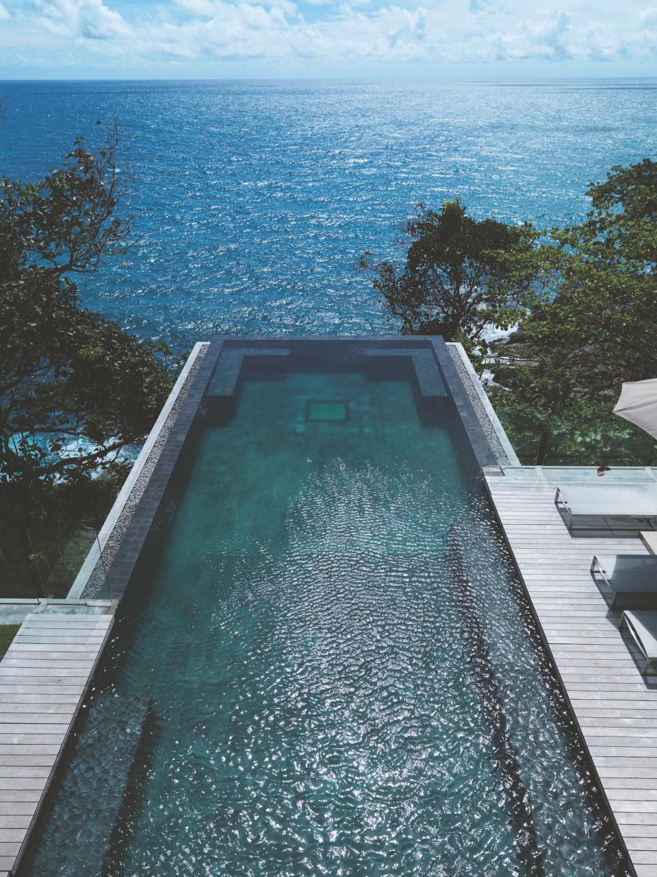 Villa Amanzi Kamala in Phuket, Thailand, was designed by the firm Original Vision, which took inspiration from the large granite formations nearby. The indoor and outdoor spaces flow together thanks to large glass partitions, and an impressive infinity pool offers views of the sea and gardens.