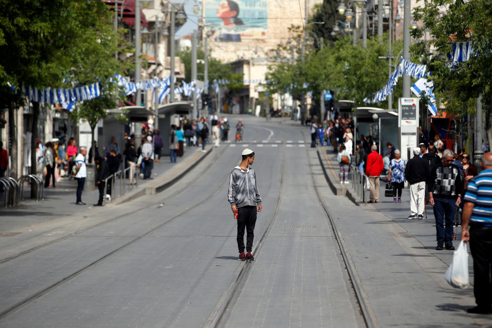 People stand still as a two-minute siren marking the annual Israeli Holocaust Remembrance Day is heard in Jerusalem on April 12, 2018.