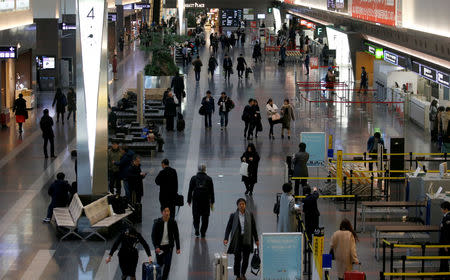 FILE PHOTO: Passengers are seen in front of security check at the Tokyo International Airport, commonly known as Haneda Airport, in Tokyo, Japan January 10, 2018. REUTERS/Toru Hanai/File Photo