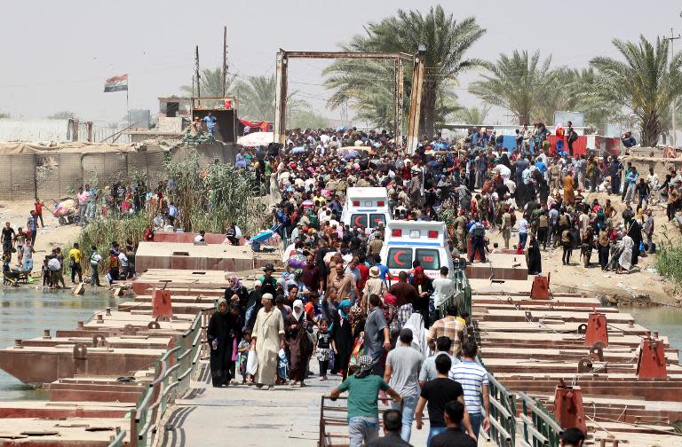 Iraqi residents from Ramadi, who fled their homes as Islamic State group militants tightened their siege, wait to cross Bzeibez bridge on May 20, 2015