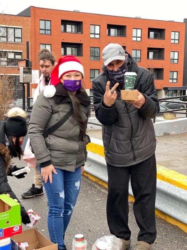 Cindy Ha (left) started out selling handmade masks when the pandemic hit. The proceeds go to local charities, and pay for prepared meals she hands out to those in need. (Submitted by Melissa Chin - image credit)