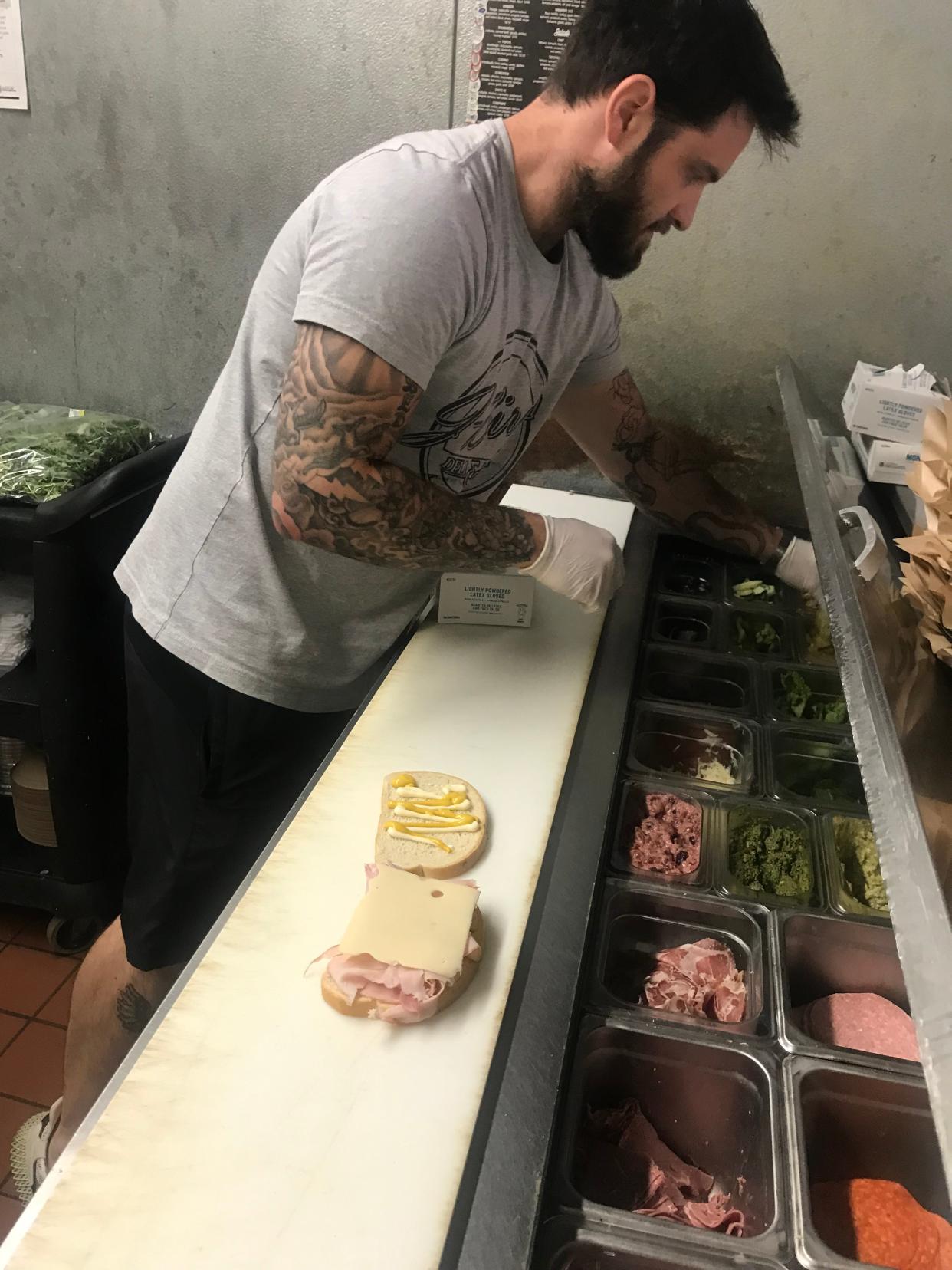 Justin Webber whips up a sandwich from scratch during a photoshoot in the kitchen of his sandwich shop, J-Bird's Deli & Ales.