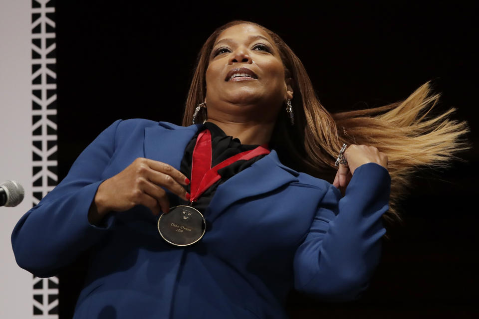 FILE - This Oct. 22, 2019 file photo shows musician and actress Queen Latifah fixing her hair after receiving the W.E.B. Dubois Medal for her contributions to black history and culture during ceremonies at Harvard University in Cambridge, Mass.From Oscar winners to stars on the rise, many African American actresses have similar stories about hair struggles in Hollywood. Queen Latifah said she encountered stylists who didn’t know what to do with her hair, particularly early in her career. (AP Photo/Elise Amendola, File)