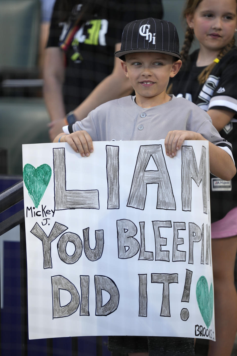 A young fan of Chicago White Sox's Liam Hendriks holds a sign during a ceremony honoring Hendrik's before a baseball game against the Los Angeles Angels, Monday, May 29, 2023, in Chicago. Hendriks returns to the active lineup after battling cancer at the start of the season. (AP Photo/Charles Rex Arbogast)