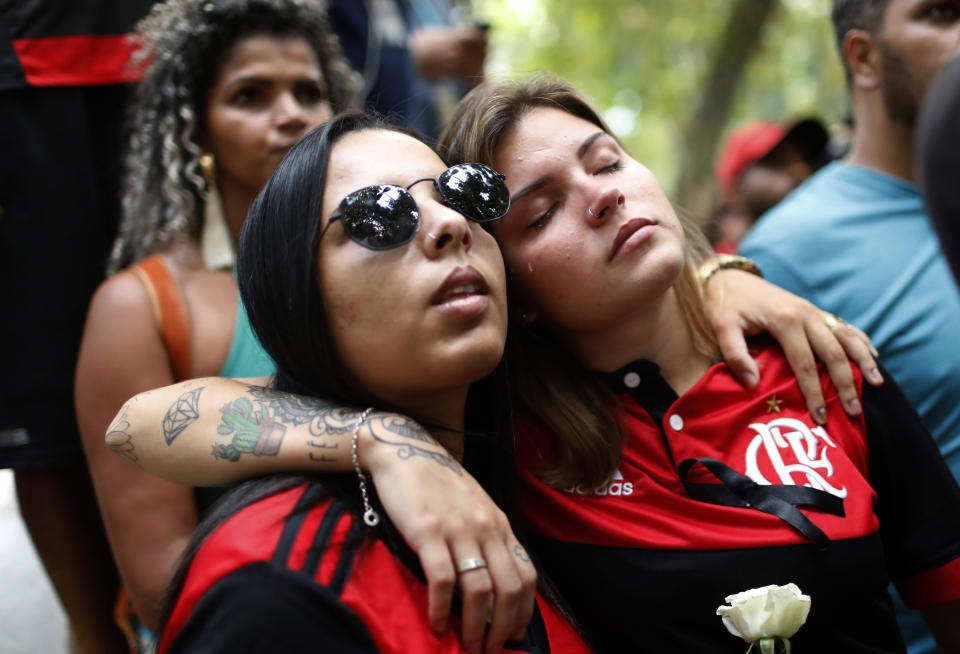 Flamengo soccer fans gather to honor the teenage players killed by a fire, in Rio de Janeiro, Brazil, Saturday, Feb. 9, 2019. A fire early Friday swept through the sleeping quarters of an academy for Brazil's popular professional soccer club Flamengo, killing several and injuring others, most likely teenage players, authorities said. (AP Photo/Silvia Izquierdo)