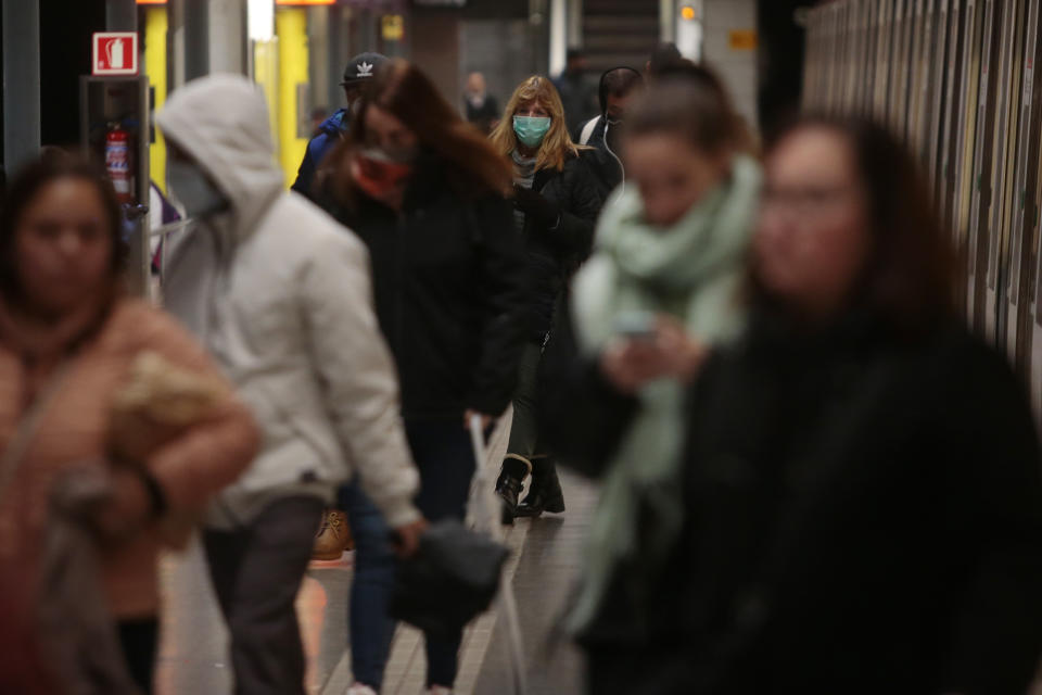 Passengers walk in a train station in Barcelona, Spain, Monday, March 16, 2020. Spain's interior minister, Fernando Grande-Marlaska, says the government will re-establish land borders for people starting at midnight on Monday, allowing only the return of residents in Spain. For most people, the new COVID-19 coronavirus causes only mild or moderate symptoms. For some it can cause more severe illness. (AP Photo/Joan Mateu)